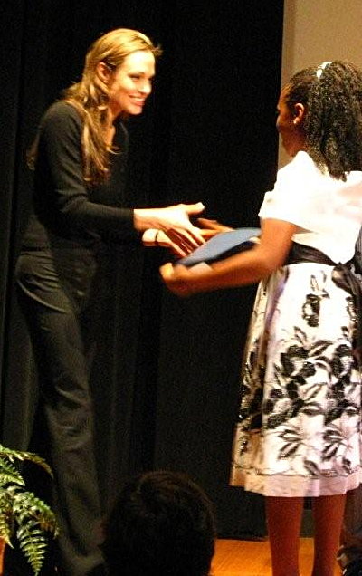 Angelina Jolie congratulates a winner of her poster contest at the World Refugee Day event at the National Geographic Museum in Washington, D.C.