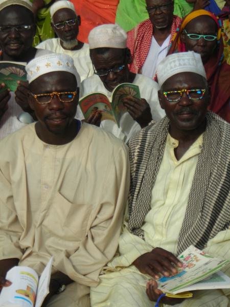 Darfuri men trying new reading glasses in Chad